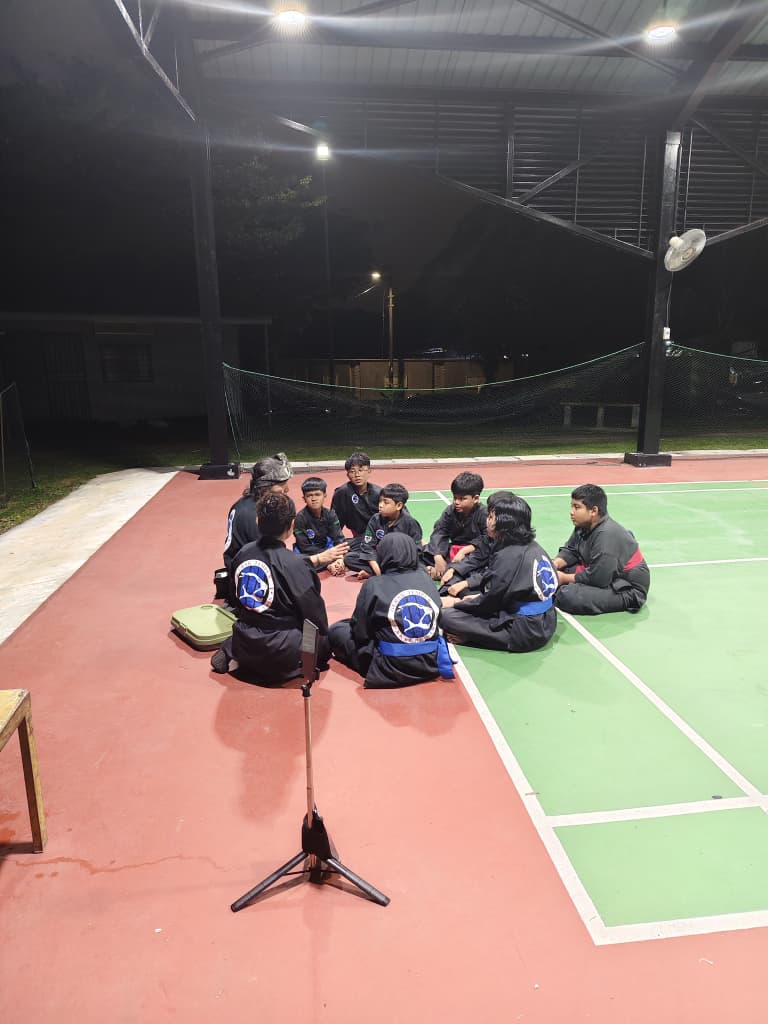 Pelajar GTP duduk berkelompok bersama guru selepas sesi latihan